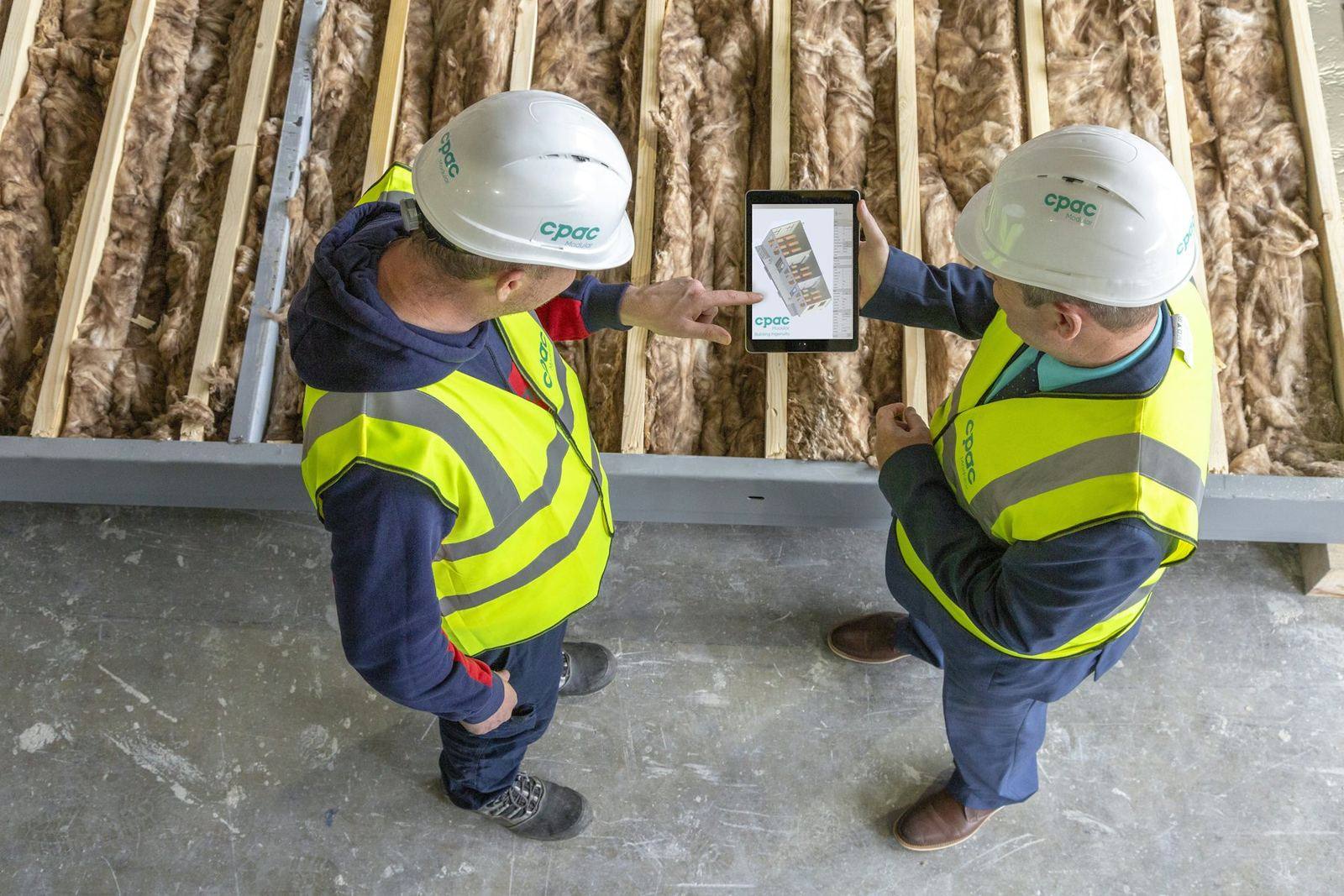 Deux techniciens étudient des plans sur une tablette
