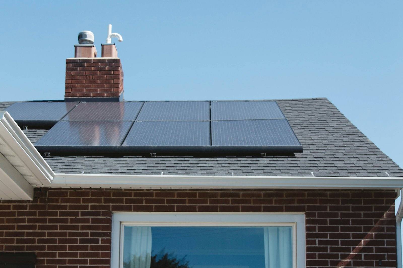 Maison en briques équipée de panneaux solaires en toiture