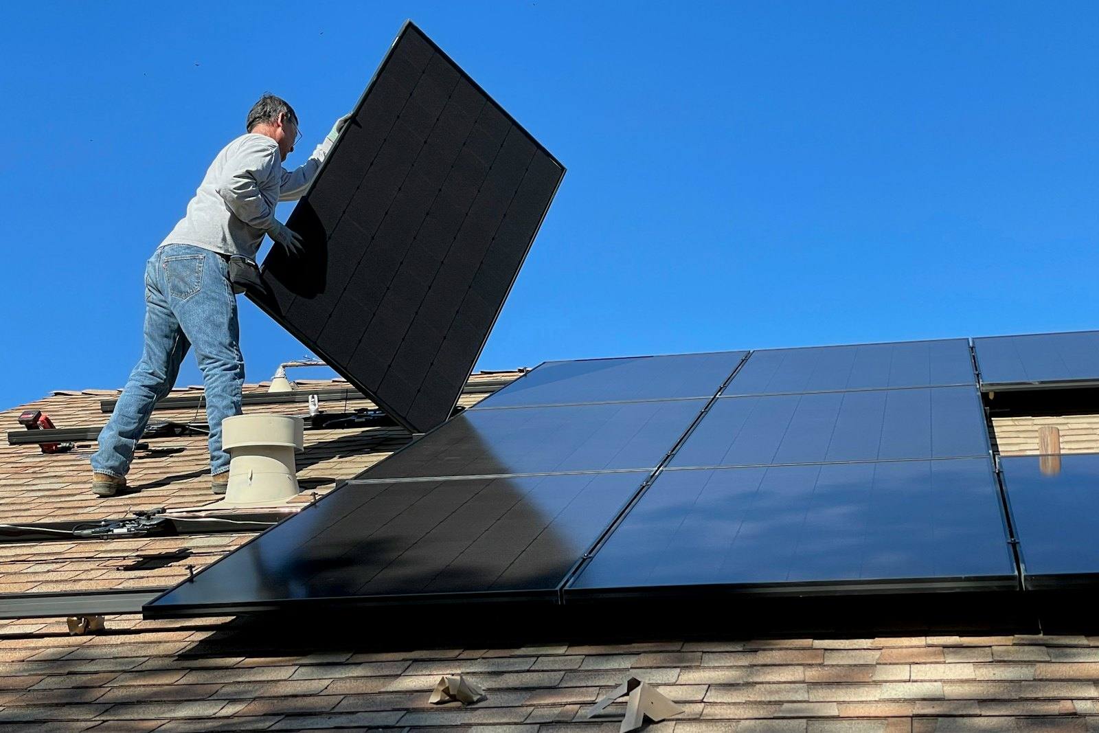 Installateur posant un panneau photovoltaïque sur une toiture
